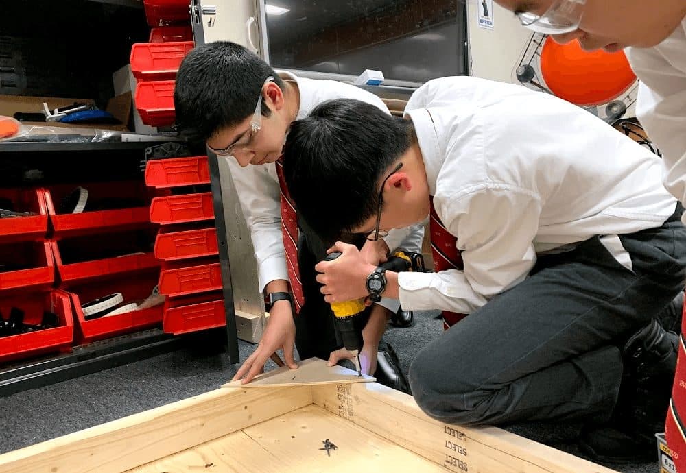 Two students working on the robot at the bench
