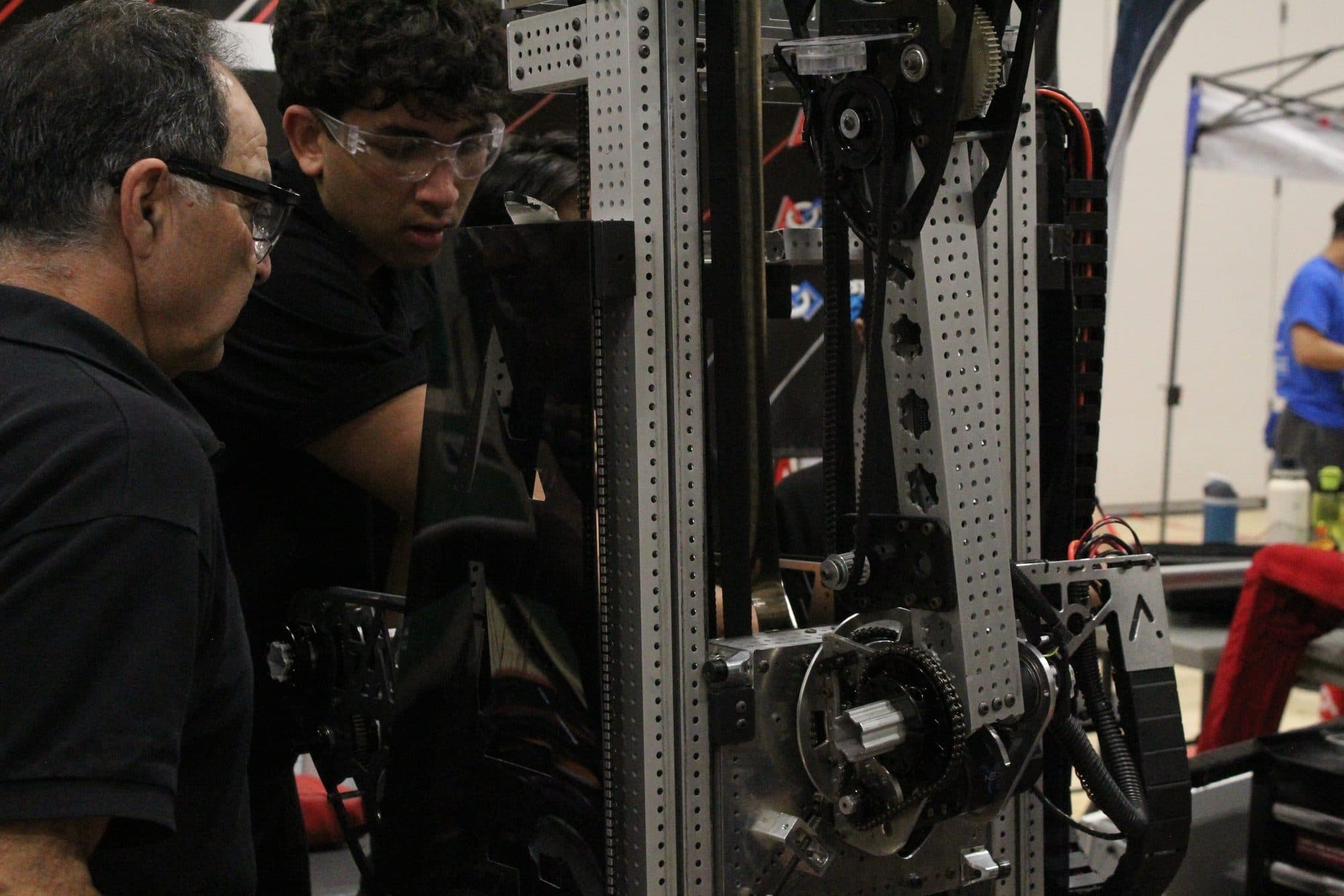 Students wiring the robot in the pit